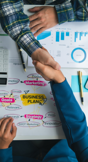 Handshake over business plan and charts.